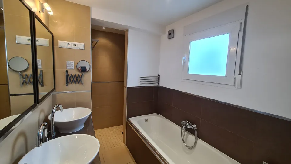 Badezimmer mit Badewanne und zwei Waschbecken