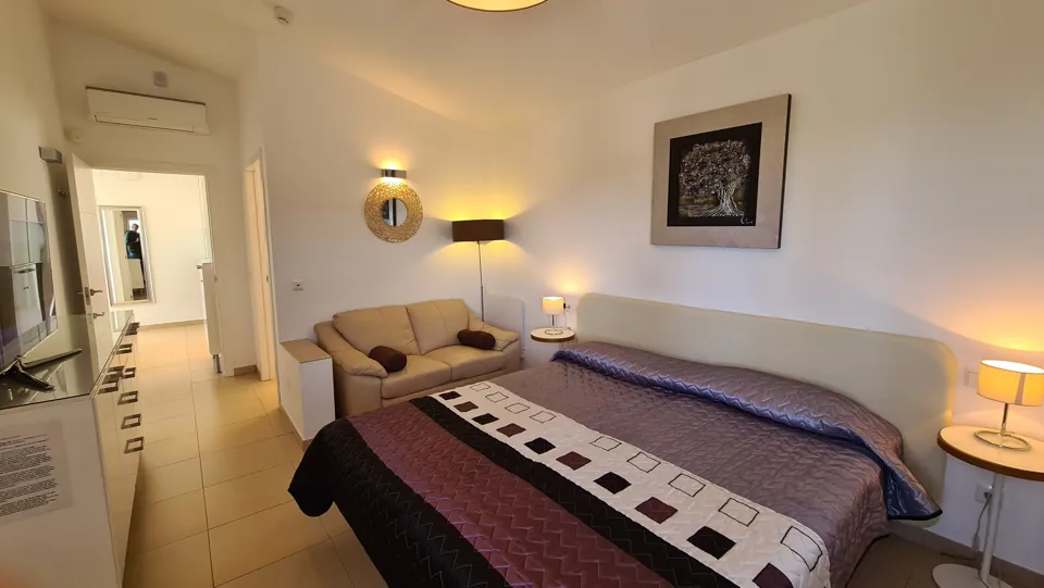 Erstes Schlafzimmer mit Doppelbett und Sofa